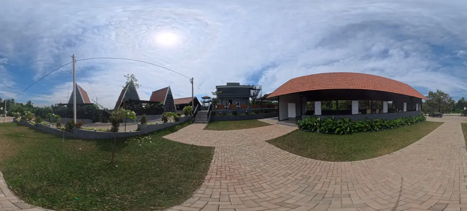 360-degree panoramic photo of a resort courtyard with cottage-style villas and a tiled-roof pavilion, captured for a virtual tour